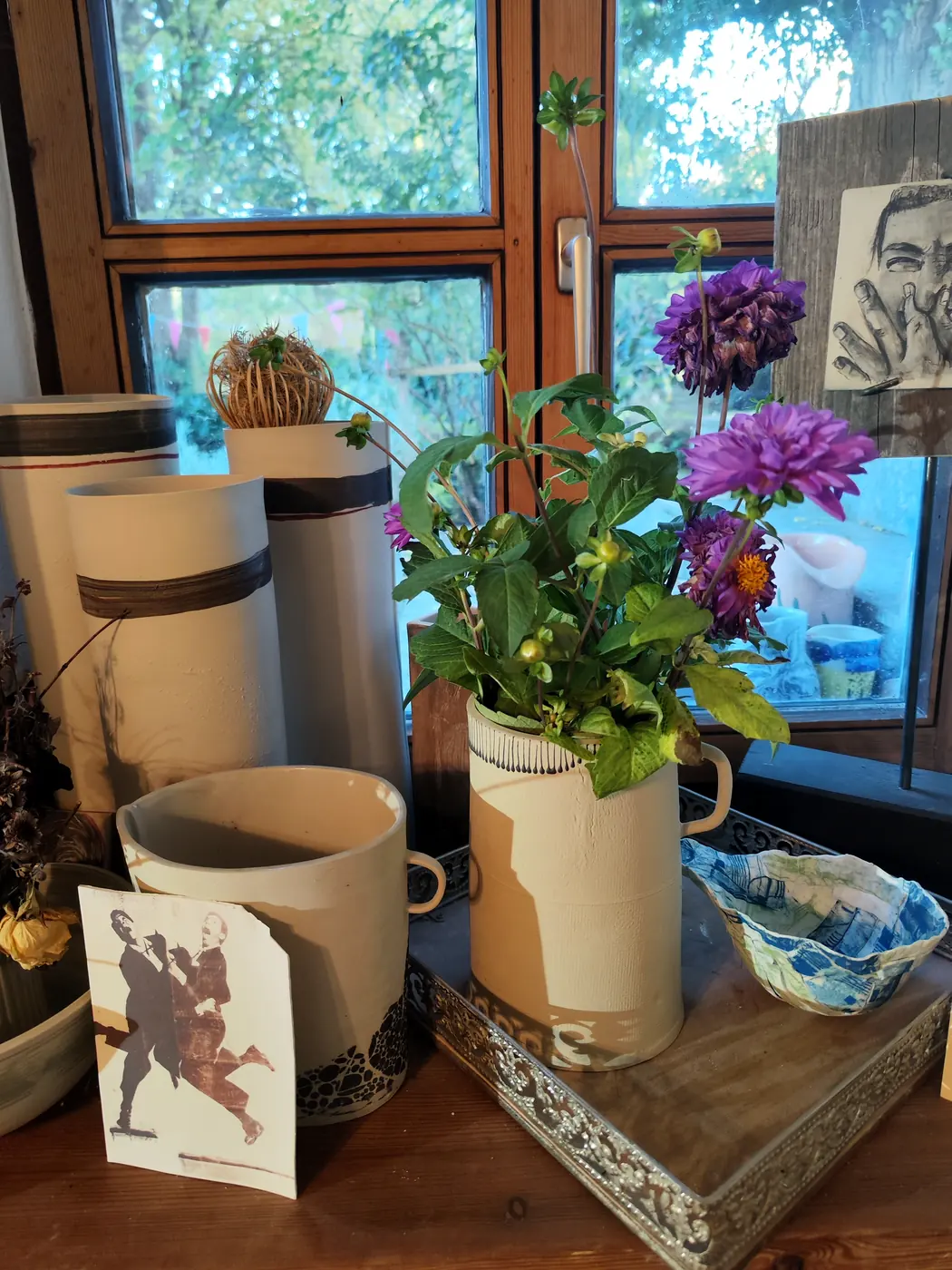 Gefäße mit Dahlien auf der Fensterbank, daneben eine blaue Schale und ein Druck mit Tanzpaar